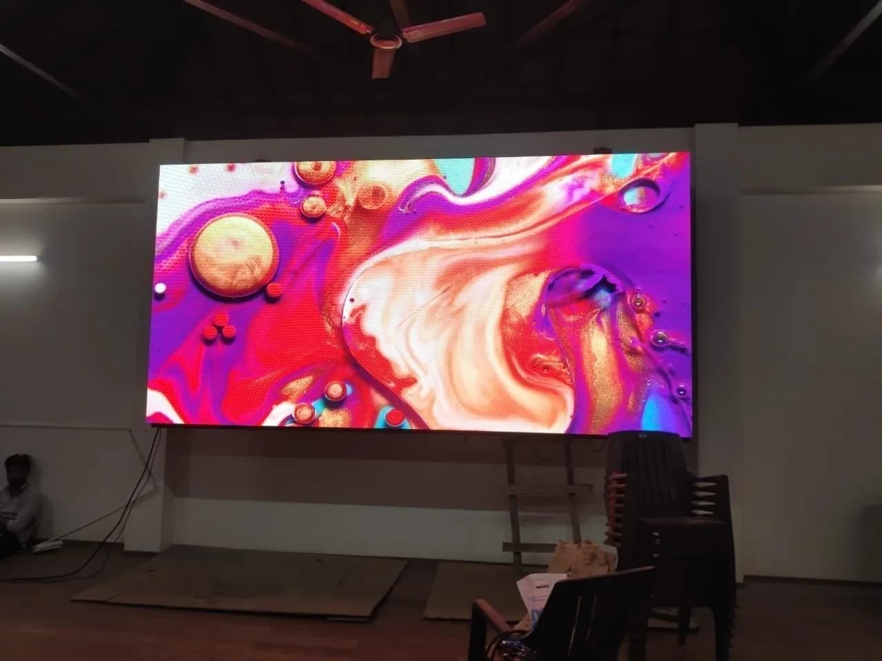 LED screen in a hall showing colourful abstract art
