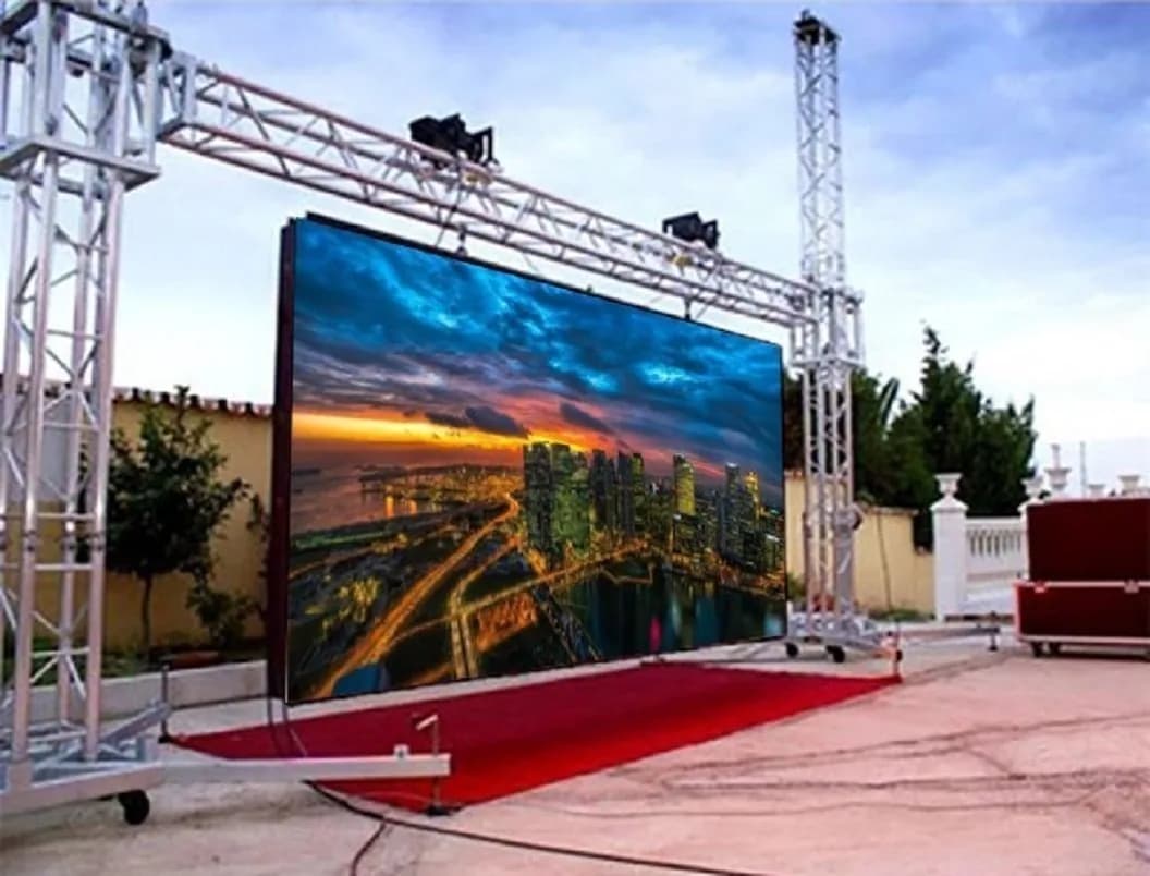 Rental LED screen on a truss with a red carpet, showing a city at dusk