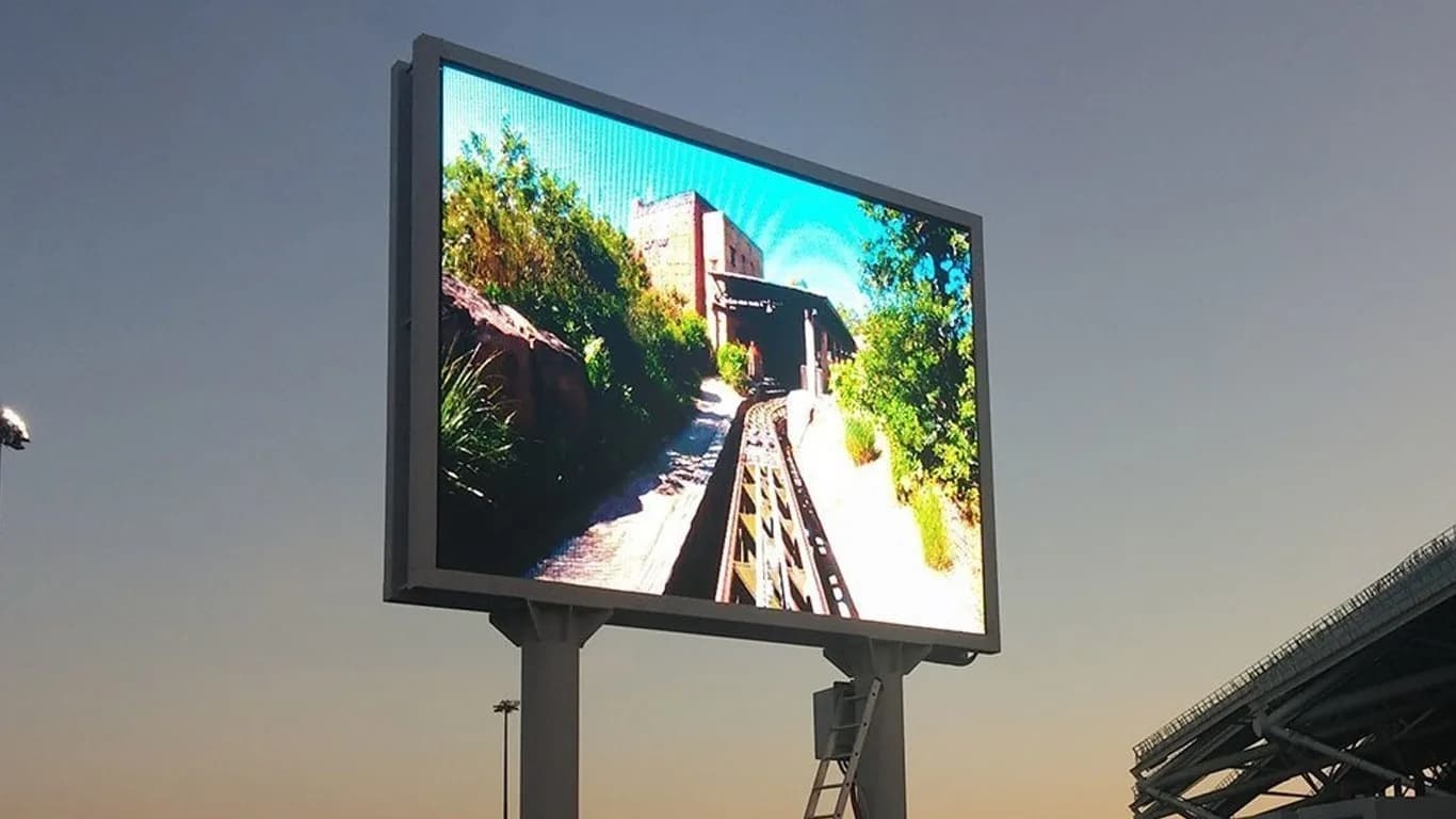 Roadside LED screen on a pole at dusk